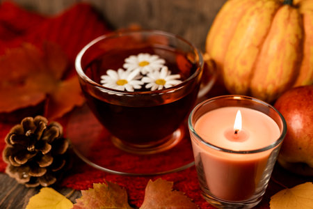 Autumn composition, tea, pumpkins, candle on the table. Autumn comfort at home. High quality photoの写真素材