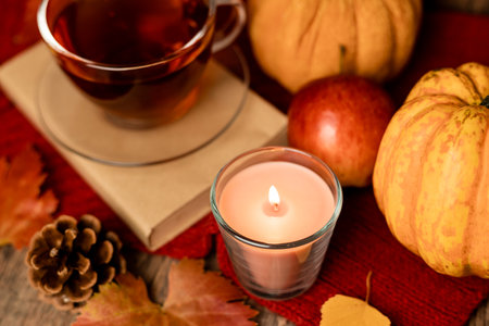 Autumn composition, tea, pumpkins, candle on the table. Autumn comfort at home. High quality photoの写真素材