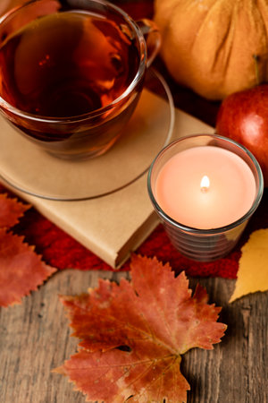 Autumn composition, tea, pumpkins, candle on the table. Autumn comfort at home. High quality photoの写真素材