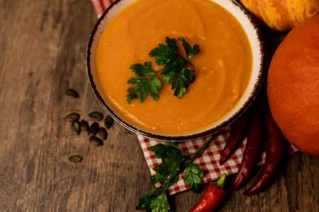 A bowl of pumpkin soup on the table. Autumn vegetables. Homemade food. Healthy nutrition. High quality photoの写真素材