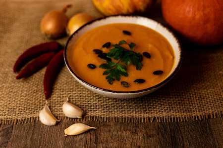 A bowl of pumpkin soup on the table. Autumn vegetables. Homemade food. Healthy nutrition. High quality photoの写真素材