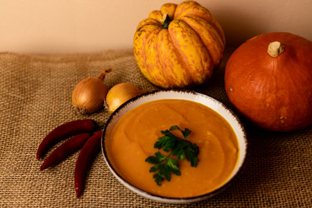 A bowl of pumpkin soup on the table. Autumn vegetables. Homemade food. Healthy nutrition. High quality photoの写真素材