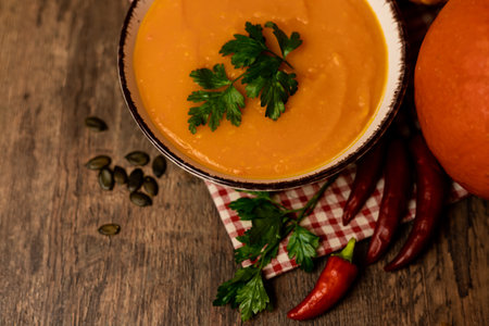 A bowl of pumpkin soup on the table. Autumn vegetables. Homemade food. Healthy nutrition. High quality photoの写真素材