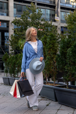 Young woman walking down the street with bags after shopping. High quality photoの写真素材