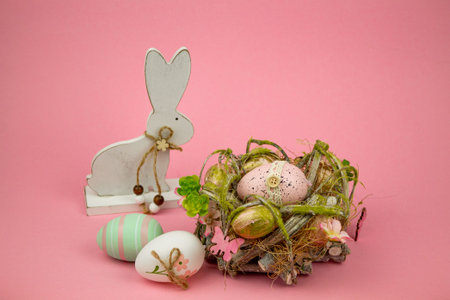 Colorful Easter eggs in a basket on a pink background. Easter Bunny. High quality photo