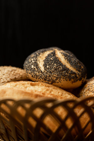 Freshly baked bun with poppy seeds. Assorted fresh pastries. Bread in a wicker basket on the table.