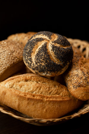 A bun with poppy seeds is in a basket with bread. Poppy filling. High quality photo
