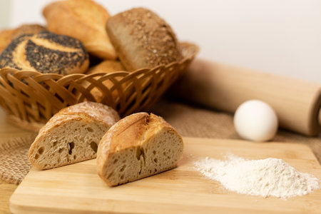 Sliced bread on the table, flour, egg. Homemade pastries. Freshly baked buns are on the table. The process of baking bread. High quality photoの写真素材