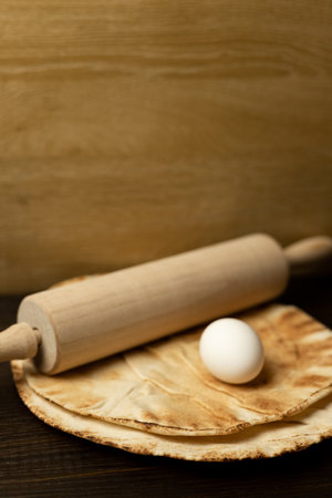 Pita bread, egg and rolling pin. Homemade pastries. Preparation of pita bread. High quality photoの写真素材