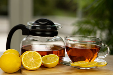 Glass cup of tea, teapot, sliced lemons on the table. Kettle with tea. Lemon tea. High quality photoの写真素材