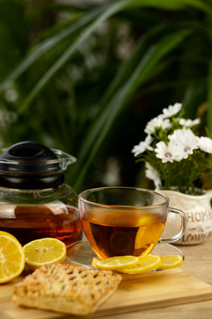 Glass cup of tea, teapot, sliced lemons on the table. Kettle with tea. Lemon tea. High quality photoの写真素材