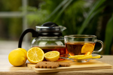 Glass cup of tea, teapot, sliced lemons on the table. Kettle with tea. Lemon tea. High quality photoの写真素材