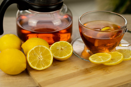 Glass cup of tea, teapot, sliced lemons on the table. Kettle with tea. Lemon tea. High quality photoの写真素材