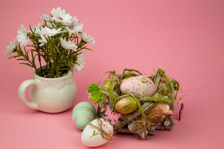 Easter colorful eggs on a pink background. Easter Composition Eggs in the Nest and Flowers. High quality photoの写真素材