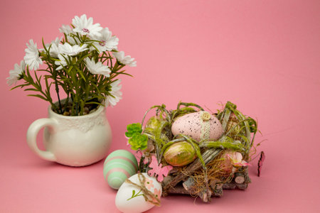 Easter colorful eggs on a pink background. Easter Composition Eggs in the Nest and Flowers. High quality photoの写真素材