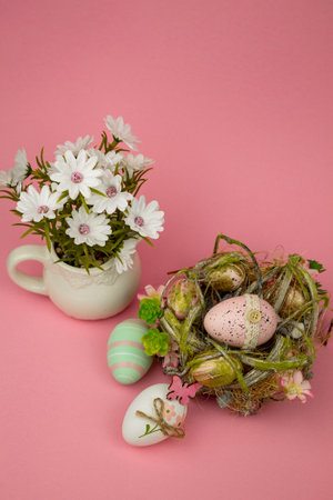 Easter colorful eggs on a pink background. Easter Composition Eggs in the Nest and Flowers. High quality photoの写真素材