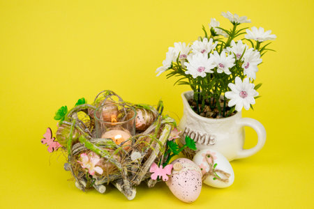 Easter eggs and a candle. View from above. Easter colorful eggs on a yellow background. High quality photoの写真素材
