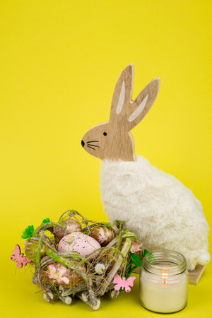 Nest with Easter eggs and a rabbit on a yellow background. Easter eggs. High quality photoの写真素材