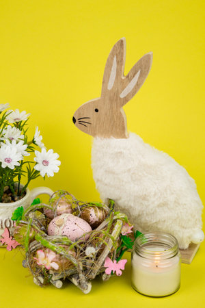 Nest with Easter eggs and a rabbit on a yellow background. Easter eggs. High quality photoの写真素材