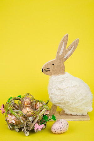 Nest with Easter eggs and a rabbit on a yellow background. Easter eggs. High quality photoの写真素材