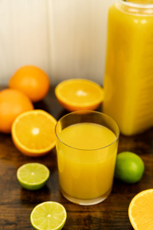 Cut oranges and limes on the table. A glass of orange juice. Citrus. High quality photoの写真素材