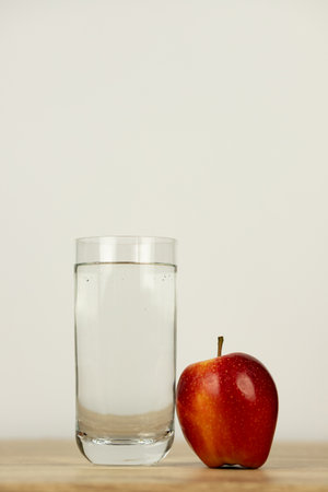 An apple and a glass of water on the table. High quality photoの写真素材