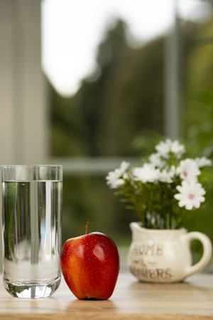 An apple and a glass of water on the table. High quality photoの写真素材