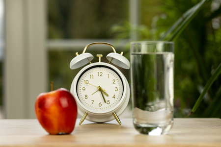 An apple and a glass of water on the table. High quality photoの写真素材