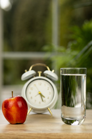 An apple and a glass of water on the table. High quality photoの写真素材