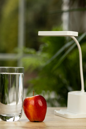 An apple and a glass of water on the table. High quality photoの写真素材