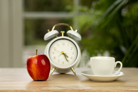 It's lunch time. Alarm clock, apple and cup of coffee. High quality photoの写真素材