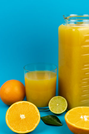 A glass of orange juice on a blue background. Oranges and juice close-up. High quality photoの写真素材