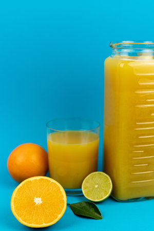 A glass of orange juice on a blue background. Oranges and juice close-up. High quality photoの写真素材