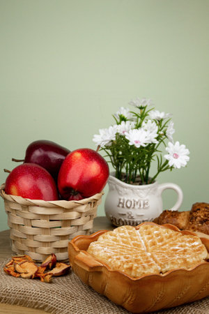 Freshly baked waffle on the table. Red apples in a basket on the table. Delicious and healthy breakfast. High quality photoの写真素材