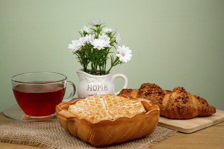 Waffles, croissants, tea on the table. Delicious homemade breakfast. Homemade cakes. High quality photoの写真素材