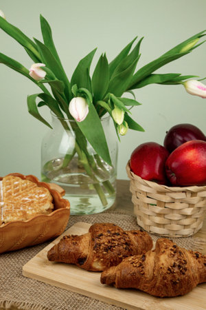 Freshly baked waffle on the table. Red apples in a basket on the table. Delicious and healthy breakfast.の写真素材
