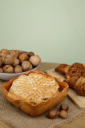 Delicious homemade waffles on the table. Walnuts and croissants. High quality photoの写真素材
