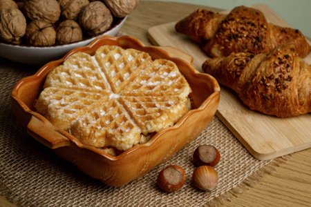 Delicious homemade waffles on the table. Walnuts and croissants. High quality photoの写真素材