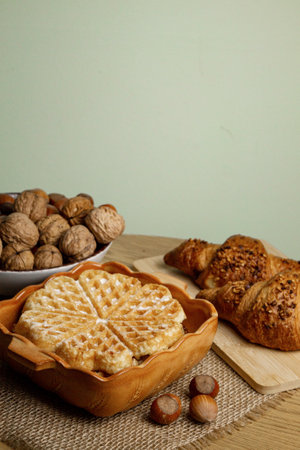 Delicious homemade waffles on the table. Walnuts and croissants. High quality photoの写真素材