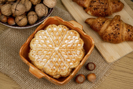 Delicious homemade waffles on the table. Walnuts and croissants. High quality photoの写真素材