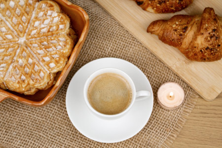 A cup of coffee, waffles and croissants on the table. Breakfast with coffee. Homemade pastries. Top view. High quality photoの写真素材