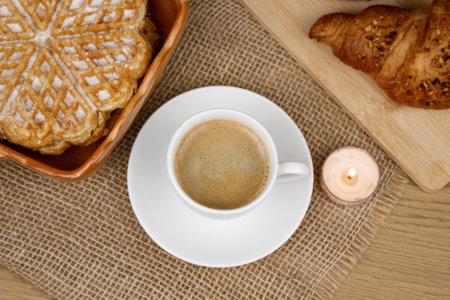 A cup of coffee, waffles and croissants on the table. Breakfast with coffee. Homemade pastries. Top view. High quality photoの写真素材