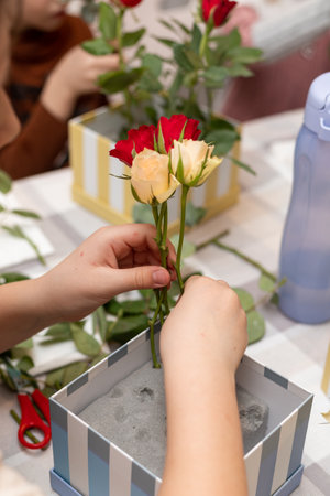 A child makes a handicraft with his own hands for Mother's Day. Boy making a bouquet for his mother. High quality photoの写真素材