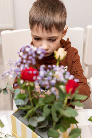 A child makes a handicraft with his own hands for Mother's Day. Boy making a bouquet for his mother. High quality photoの写真素材