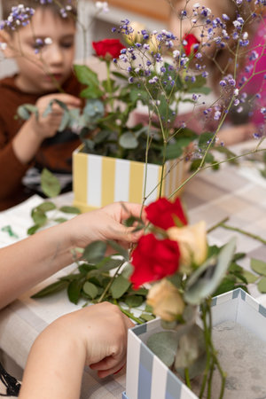 A child makes a handicraft with his own hands for Mother's Day. Boy making a bouquet for his mother. High quality photoの写真素材