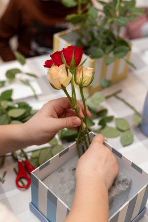 A child makes a handicraft with his own hands for Mother's Day. Boy making a bouquet for his mother. High quality photoの写真素材