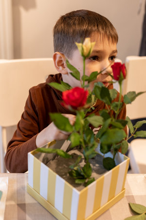 A child makes a handicraft with his own hands for Mother's Day. Boy making a bouquet for his mother. High quality photoの写真素材
