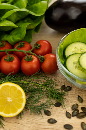 Red tomatoes, lettuce leaves on the table close-up. Vegetables for salad on the kitchen table. High quality photoの写真素材