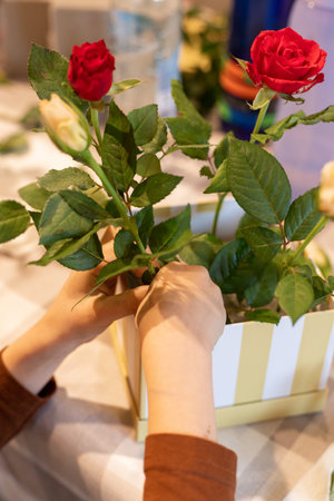 A child makes a handicraft with his own hands for Mother's Day. Boy making a bouquet for his mother. High quality photoの写真素材