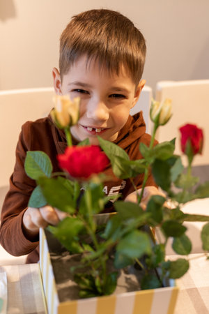 A child makes a handicraft with his own hands for Mother's Day. Boy making a bouquet for his mother. High quality photoの写真素材